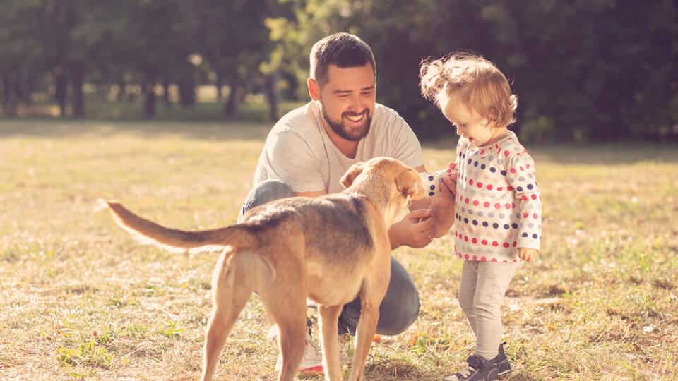 Father and daughter spending time outside with pet dog