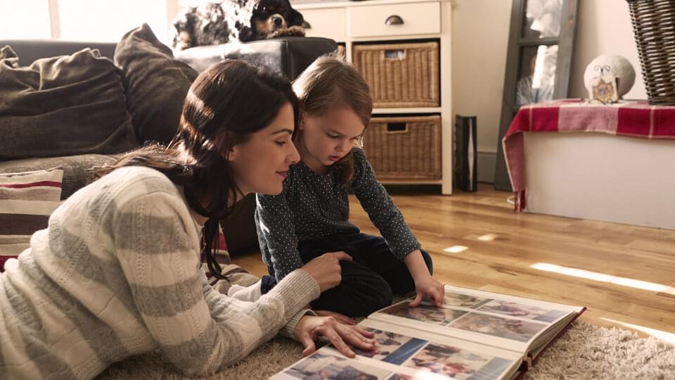 Mother and daughter looking at family photo album
